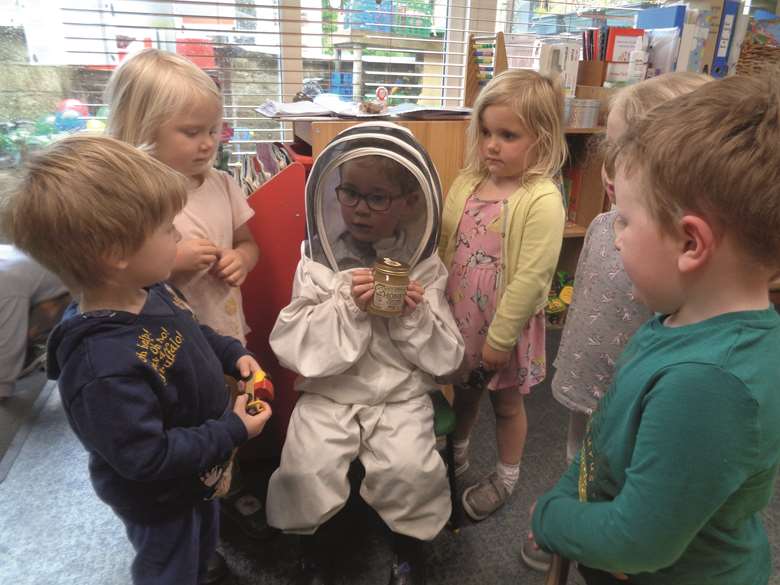Ted wore a beekeeping suit and brought a jar of honey into the nursery