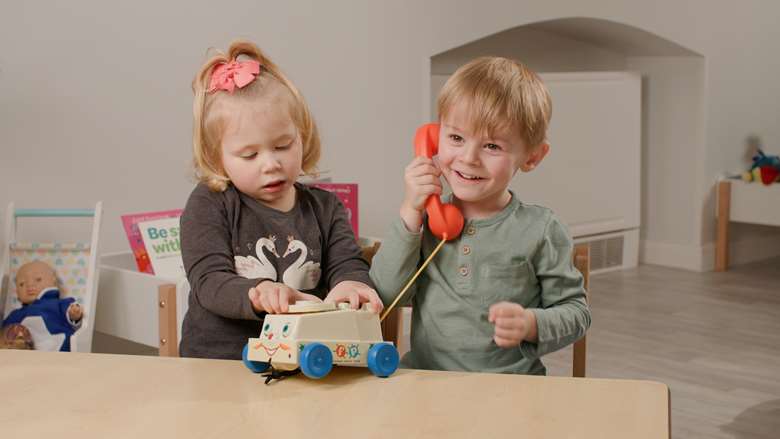 Nursery children playing with a Fisher Price telephone, first released in the 1960s, PHOTO Busy Bees