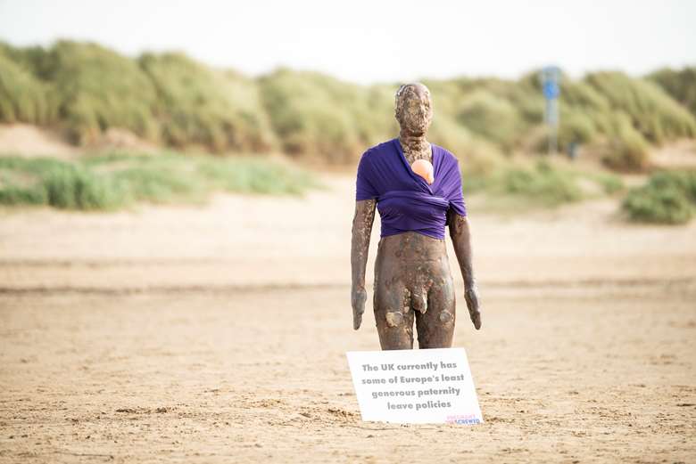 The iconic Antony Gormley statues on Crosby Beach have 'babies' strapped on to them to represent the small number of dads taking shared parental leave PHOTO: Joe Roper