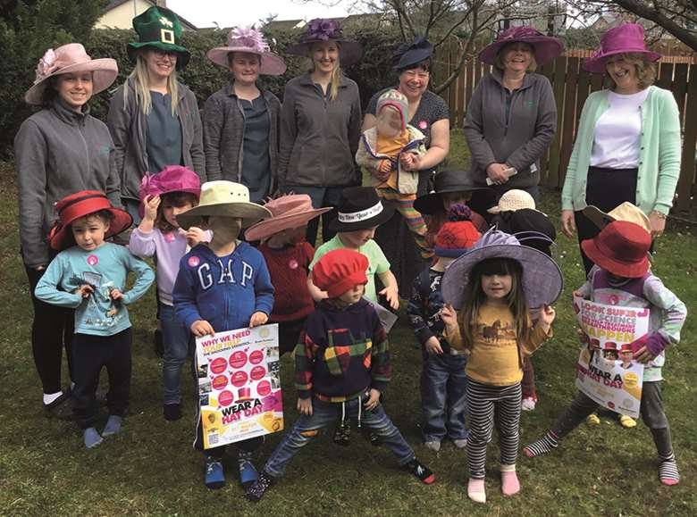 Children and staff from Poppies Pre-school in Laurencekirk, Aberdeenshire, model the donated hats