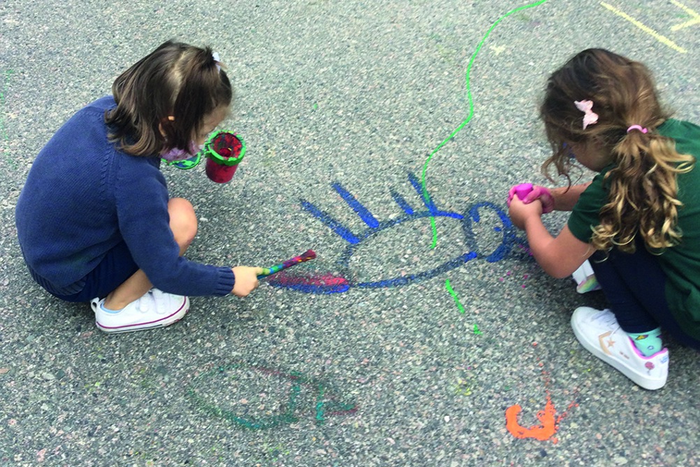 Children use the ground outside as a large-scale canvas PHOTO Claire Martin